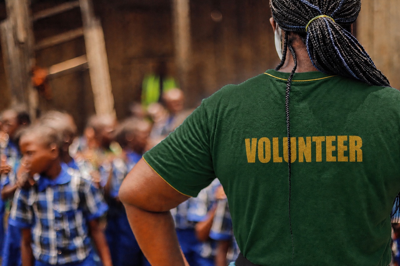 Volunteer supporting children at a community programme